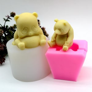 May include: Two silicone molds for making panda bear shaped cakes or other treats. The molds are pink and white and feature a small and a large panda bear.
