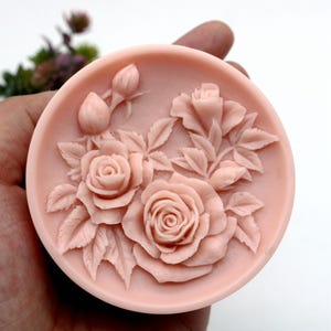 Pu&ograve; includere: Un sapone rotondo rosa con un designo dettagliato di rose e foglie. Il sapone &egrave; fatto in uno stampo e ha un design in rilievo tridimensionale.