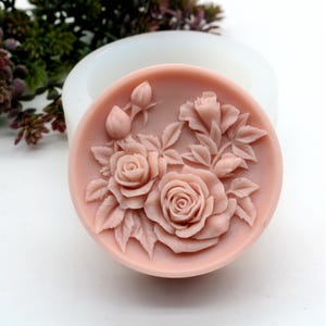 Pu&ograve; includere: Uno stampo rotondo in silicone per realizzare sapone o candele. Lo stampo presenta un design dettagliato di rose rosa e foglie.