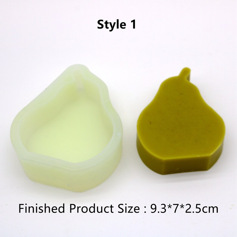 Pu&ograve; includere: Uno stampo in silicone bianco a forma di pera, accanto a un prodotto finito a forma di pera realizzato in materiale verde. Il prodotto finito misura 9,37 cm per 7 cm per 2,5 cm. Stile 1.