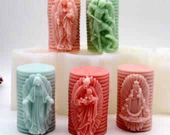 May include: Five cylindrical silicone molds for making candles. The molds are white and have a ribbed texture. Each mold features a different religious figure in relief, including the Virgin Mary, Jesus, and Saint Michael.