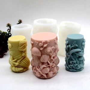 Può includere: Una collezione di candele cilindriche in vari colori, tra cui giallo, rosa e blu. Le candele sono intagliate con disegni a tema marino come conchiglie, meduse e alghe. Sono visibili anche diversi stampi non colorati.
