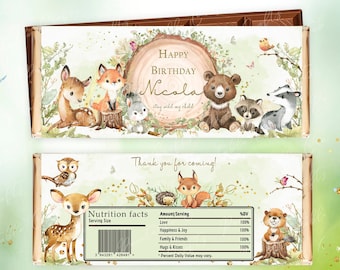 May include: Woodland-themed chocolate bar wrapper with a green and brown color scheme. The wrapper features a circle with the text "Happy Birthday Nicola" and a group of woodland animals including a deer, fox, bear, raccoon, and squirrel. The bottom of the wrapper has a nutrition facts label with the text "Amount/Serving: Love, Happiness & Joy, Family & Friends, Hugs & Kisses".
