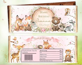 May include: Pink and brown woodland animal themed chocolate bar wrapper with the text "Happy Birthday Joanna Wish you the best!" and "Thank you for coming!"  The wrapper features a deer, fox, bear, raccoon, and owl. The nutrition facts label lists "Love", "Happiness & Joy", "Family & Friends", and "Hugs & Kisses" as ingredients.