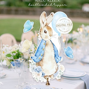 May include: Peter Rabbit double-sided topper for a cake or centerpiece. The topper features a watercolor illustration of Peter Rabbit in a blue jacket holding a blue balloon with the text "PERSONAL USE BY DIGITAL FILE PPC PRINT IT YOURSELF".