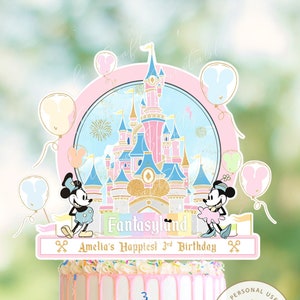 May include: A pink and blue cake topper featuring a cartoon image of Mickey and Minnie Mouse in front of a pink and blue castle with fireworks. The text "Fantasyland" and "Amelia's Happiest 3rd Birthday" is printed on the topper.