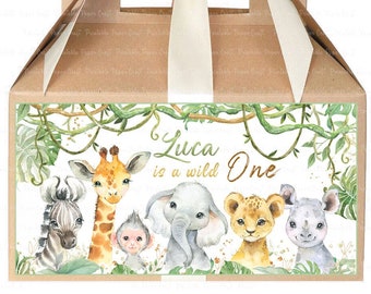 Op de afbeelding: Een bruine kartonnen cadeaudoos met een wit satijnen lint en strik. De doos heeft een label met een junglethema en de tekst "Luca is a wild One". Het label toont een zebra, een giraffe, een aap, een olifant, een leeuw en een neushoorn.