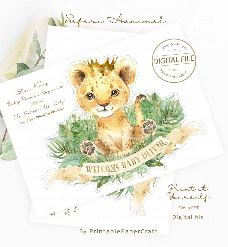 May include: A printable baby shower topper featuring a cute cartoon lion cub wearing a gold crown and surrounded by green leaves. The topper says "Welcome Baby Oliver".