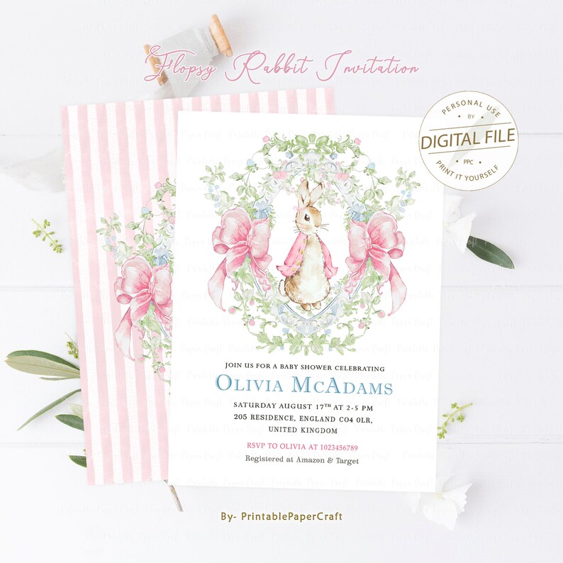 May include: A pink and white striped background with a white card featuring a watercolour illustration of a rabbit wearing a pink dress and a bow. The card is for a baby shower celebrating Olivia McAdams. The text on the card reads "Join us for a baby shower celebrating Olivia McAdams, Saturday August 17th at 2-5 PM, 205 Residence, England CO4 OLR, United Kingdom, RSVP to Olivia at 1023456789, Registered at Amazon & Target, By- PrintablePaperCraft."