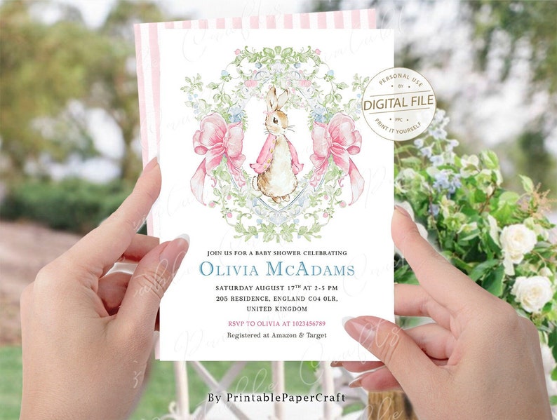 May include: A baby shower invitation featuring a watercolour illustration of a bunny rabbit wearing a pink dress and surrounded by pink bows and green foliage. The text on the invitation reads "Join us for a baby shower celebrating Olivia McAdams, Saturday August 17th at 2-5 PM, 205 Residence, England CO4 OLR, United Kingdom, RSVP to Olivia at 1023456789, Registered at Amazon & Target, By PrintablePaperCraft."
