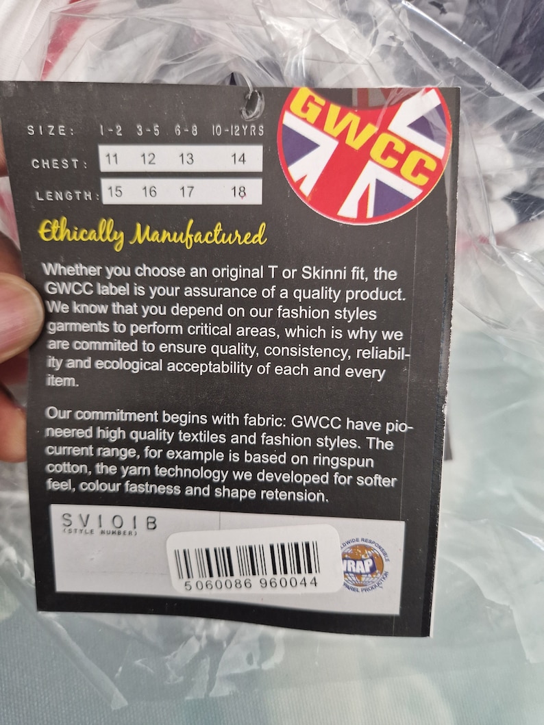 Puede incluir: Una etiqueta de ropa con el texto "GWCC" y un logotipo de la Union Jack. La etiqueta incluye medidas de talla, pecho y largo. Tambi&eacute;n es visible el texto "Ethically Manufactured". Hay un c&oacute;digo de barras y el n&uacute;mero 5060086 960044.