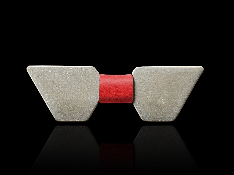 May include: A silver bow tie with a red bow in the centre.