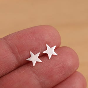 May include: A pair of silver star-shaped stud earrings.
