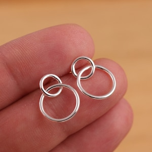 Peut inclure: Une paire de boucles d'oreilles en argent avec deux cercles entrelacés. Les boucles d'oreilles sont simples et élégantes.