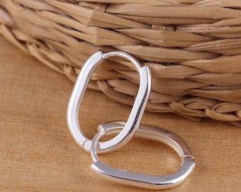 May include: A pair of silver oval hoop earrings. The earrings are simple and elegant, and they would make a great gift for any occasion.