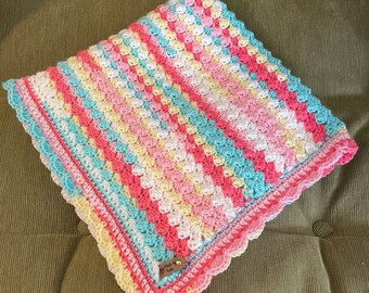 Multi color handmade crochet baby blanket with a shell scallop border in colors pink,salmon,yellow,turquoise,white