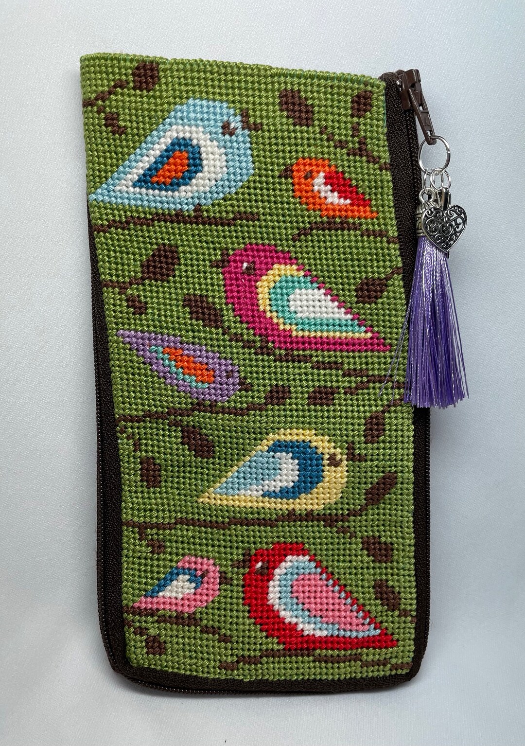 A Finished Needlepoint Eyeglass Case With Birds on Branches. It Has a
