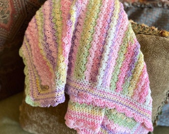 This handmade crocheted baby blanket is done in variegated looks of light green, yellow, purple and pink