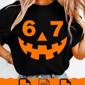 May include: Black t-shirt with an orange jack-o'-lantern face design. The design includes the numbers 6 and 7, and a triangular nose. The bottom of the image shows PNG, SVG, and EPS file icons.