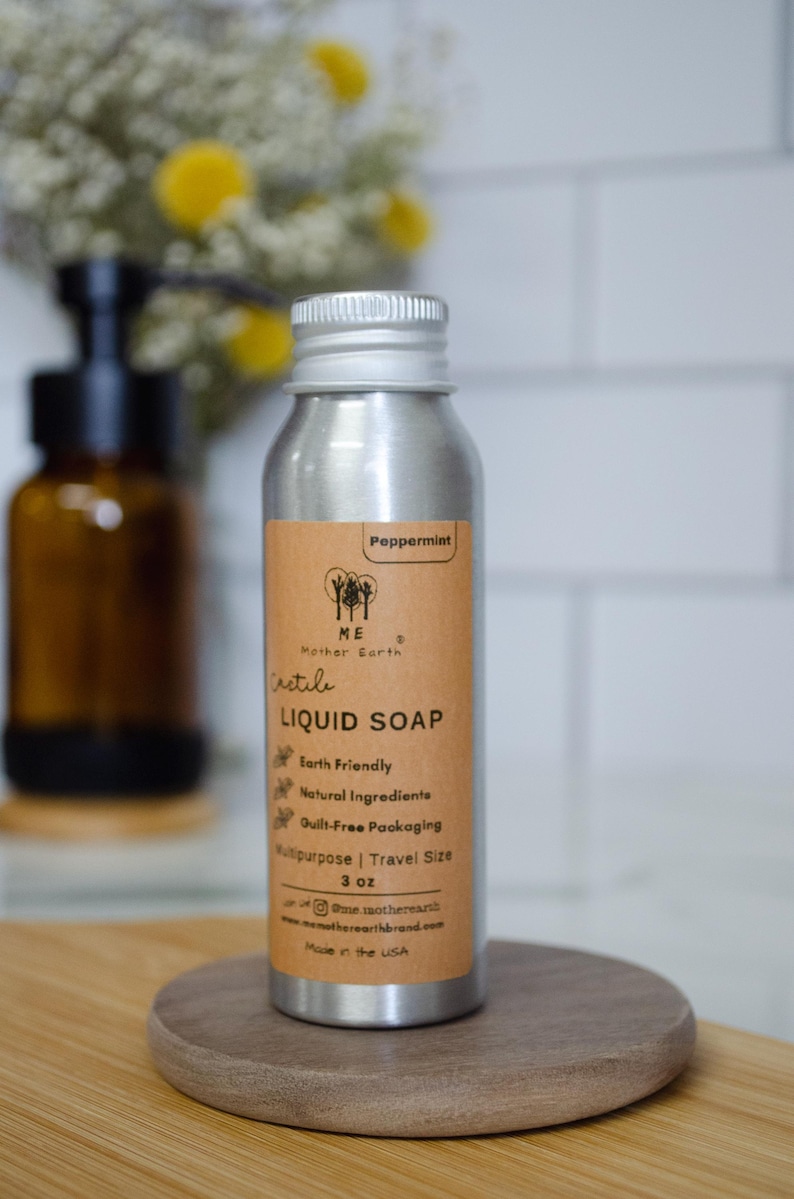 May include: A silver aluminum bottle with a brown label that reads "Peppermint", "ME Mother Earth", "irstile", "LIQUID SOAP", "Earth Friendly", "Natural Ingredients", "Guilt-Free Packaging", "Multipurpose | Travel Size", "3 oz", "@memotherearth", "memotherearthbrand.com", "Made in the USA".