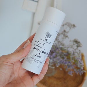 Peut inclure: Tube blanc de d&eacute;odorant naturel avec le texte "ME Mother Earth Natural Deodorant Sandalwood & Teak Handcrafted | Vegan 3.25 oz" sur l'&eacute;tiquette.