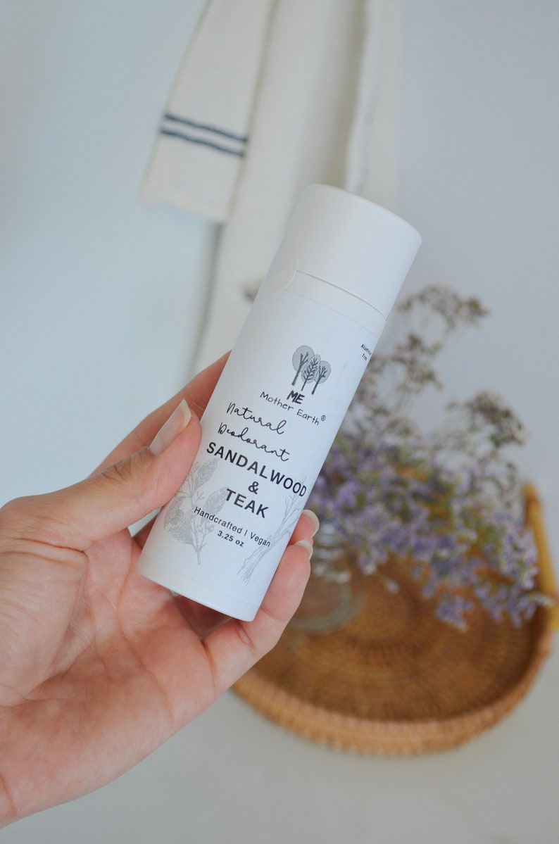 Peut inclure: Tube blanc de d&eacute;odorant naturel avec le texte "ME Mother Earth Natural Deodorant Sandalwood & Teak Handcrafted | Vegan 3.25 oz" sur l'&eacute;tiquette.