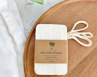May include: A rectangular, off-white loofah dish sponge with a beige cotton hanging loop. A brown paper label is wrapped around the center, printed with the text: ME Mother Earth, ECO DISH SPONGE, Double Layer Loofah Sponge, Expands when wet, Made from Plant Loofah, 3-pack.