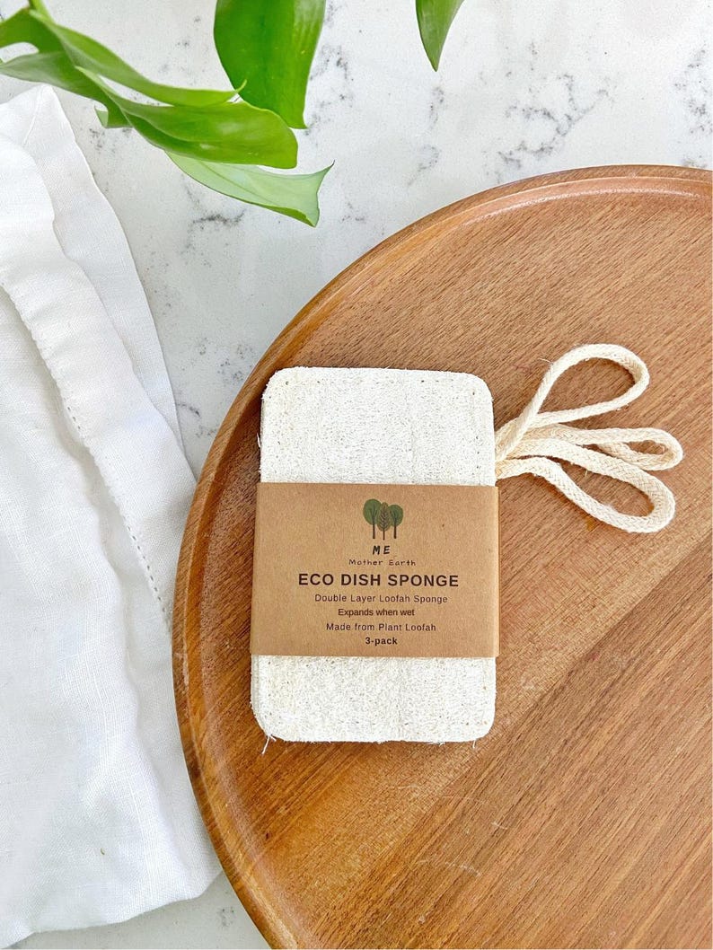 Pu&ograve; includere: Una spugna per piatti rettangolare in luffa color bianco sporco con un occhiello di sospensione in cotone beige. Un'etichetta di carta marrone &egrave; avvolta attorno al centro, stampata con il testo: ME Mother Earth, ECO DISH SPONGE, Double Layer Loofah Sponge, Expands when wet, Made from Plant Loofah, 3-pack.