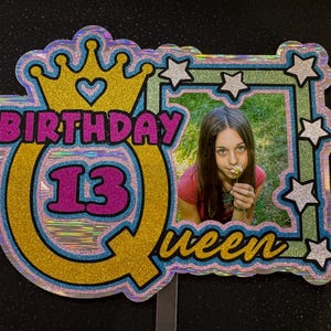 Decorazione per torta personalizzata con scritta "Regina del 13° compleanno" in cartoncino glitterato con foto, età e nome.