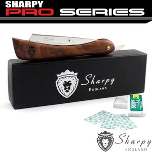 May include: A straight razor with a wooden handle and a silver blade. The razor is in a black box with the words "Sharpy England" on it. There are also several packs of razor blades in the image.