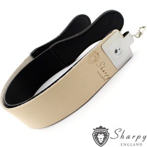 Puede incluir: Una correa de cuero para afilar cuchillas de afeitar de color beige con una correa de cuero negra y una placa de metal plateada con el texto "Sharpy England".