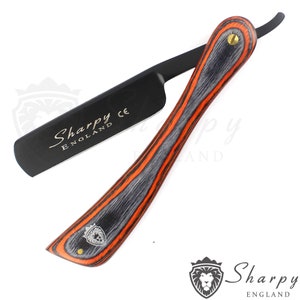 May include: A black straight razor with a black and orange wood handle. The razor has the text "Sharpy England CE" on the blade.