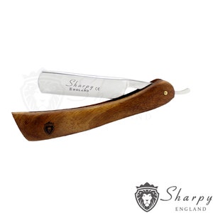 May include: A silver straight razor with a wooden handle. The razor has the text "Sharpy England CE" engraved on the blade.