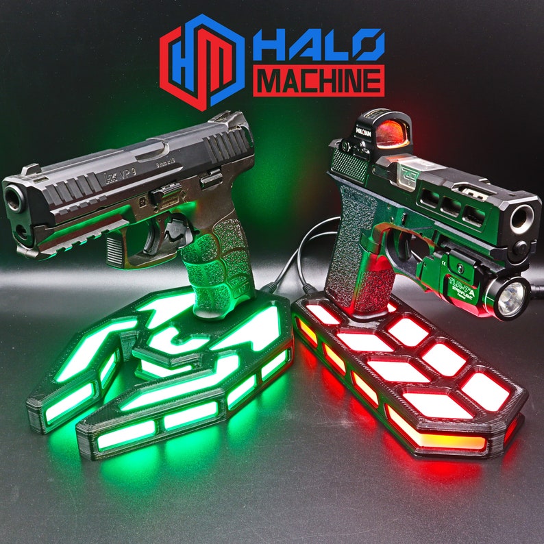 May include: Two black and silver handguns on illuminated stands. One stand glows green, the other red. The text "HALO MACHINE" is displayed above the guns in red and blue.