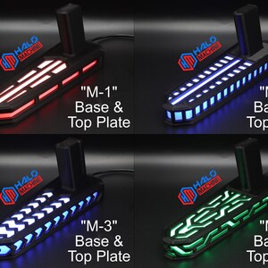 May include: Four black bases with top plates, each illuminated with different colored LED lights: red, blue, white, and green. Each base has the text "HALO MACHINE" and a label: "M-1", "M-2", "M-3", and "M-4".