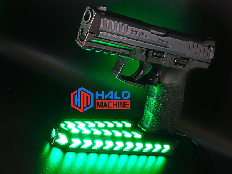 May include: A black handgun with the text "VP 9" and "9 mm x 19" is illuminated with green lights. Below the gun is a green LED light bar with arrow designs. The logo "HALO MACHINE" is visible in red and blue.