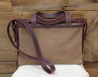 Leather waxed canvas bag/tote/purse. Leather handles/crossbody strap. Zipper closure. Outside/inside pockets. Cotton lined. Made in the USA.