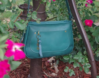 Beautiful handcrafted leather crossbody bag. Lovely bag bling included. Made in the USA.