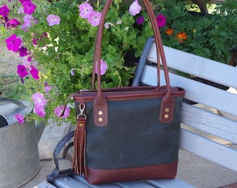 Leather waxed canvas bag/tote/purse. Dark rich full grain leather/hunter green waxed canvas. Zip top/cotton lined with pockets. Made in USA.