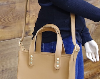 Beautiful leather bag.  Creamy brown leather. Zipper top, adjustable strap and all solid brass hardware. Made in the USA.