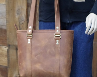 Beautiful honey colored leather bag/purse/tote.  100 percent cow hide leather. Zipper top, leather shoulder straps. Made in the USA.