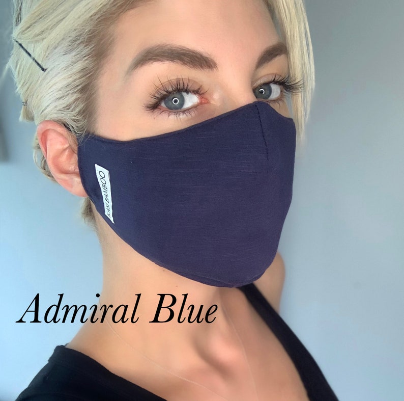 May include: A navy blue face mask with the word "COZYWEAR" printed on the side. The mask is made of a soft, breathable fabric and has a comfortable fit. The text "Admiral Blue" is written below the mask.
