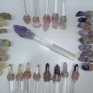 Puede incluir: Colecci&oacute;n de varitas de cristal con mangos transparentes y varias puntas de cristal. Los cristales son en tonos morado, rosa, transparente y marr&oacute;n. Las varitas tienen detalles met&aacute;licos decorativos.