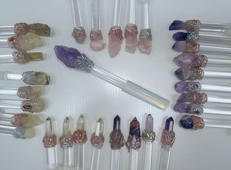 Puede incluir: Colecci&oacute;n de varitas de cristal con mangos transparentes y varias puntas de cristal. Los cristales son en tonos morado, rosa, transparente y marr&oacute;n. Las varitas tienen detalles met&aacute;licos decorativos.