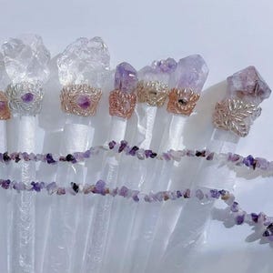 Puede incluir: Un surtido de varitas de cristal con detalles de amatista. Las varitas tienen puntas de cuarzo transparente y est&aacute;n adornadas con anillos envueltos en alambre y un collar de virutas de amatista. Los anillos son en tonos plateados y dorados.