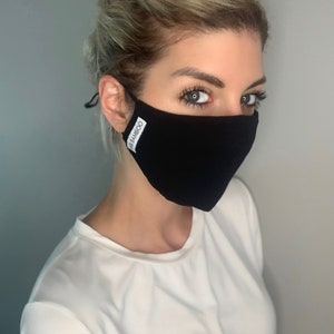May include: A black face mask with the word "BAMBOO" printed on the side. The mask is made of a soft, breathable fabric and is designed to be comfortable to wear.