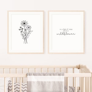 Puede incluir: Dos impresiones enmarcadas con un dibujo en blanco y negro de un ramo de flores a la izquierda y el texto "in a field of roses she is a wildflower" a la derecha.