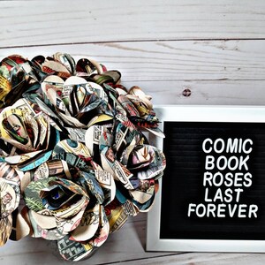K&ouml;nnte beinhalten: Ein Strau&szlig; Comic-Rosen, hergestellt aus Seiten von Vintage-Comics, mit einem Schild mit der Aufschrift "Comic-Rosen halten ewig".