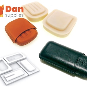 May include: Four different types of cigar cases. Two are made of leather, one is brown and one is black. The other two are made of a white material and are empty.