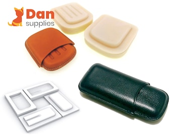 May include: Four different types of cigar cases. Two are made of leather, one is brown and one is black. The other two are made of a white material and are empty.